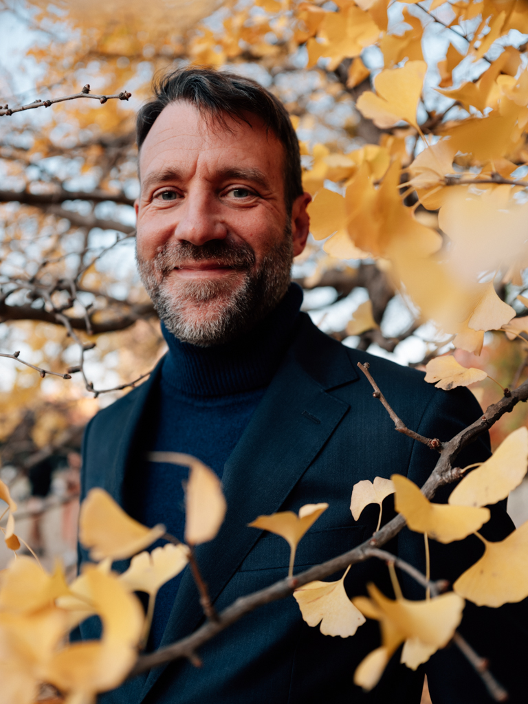 Joachim Brackx, smiling, among golden ginkgo leaves